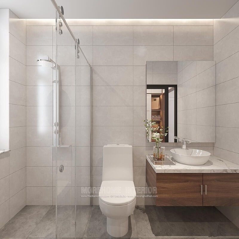 Thiết kế phòng tắm chung cư theo phong cách hiện đại đẹp với cách lựa chọn đồ vật tinh gọn nhưng lại tạo vẻ đẹp sang trọng cuốn hút từ tường ốp gạch giả bê tông, gương hình chữ nhật không khung ốp tường, phòng tắm kính cửa trượt.